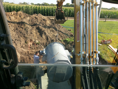 lowering a flow metering manhole into an excavation 