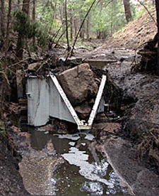 H flume with boulder lodged in the throat after a large rain event