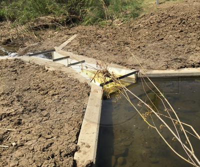 Packed earth installation of a Parshall flume