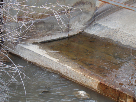 The discharge section of a non-level Parshall Flume - note the non-uniform standing water