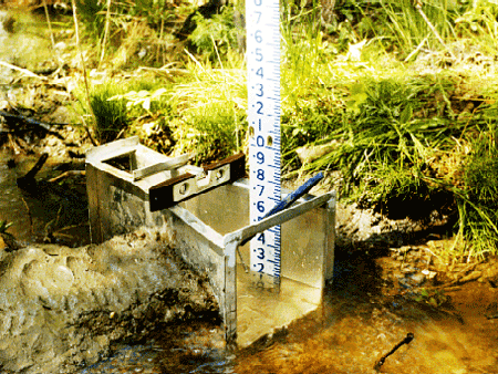 porcelain enameled staff gauge stick out of portable USGS Parshall flume