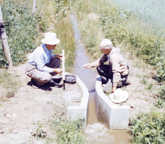 Dr. Ralph Parshall with farmer using concrete Parshall flume