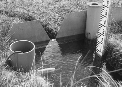 Staff gauge measuring weir head at point of measurement