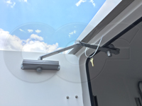 Norton door closer on an Openchannelflow fiberglass equipment shelter